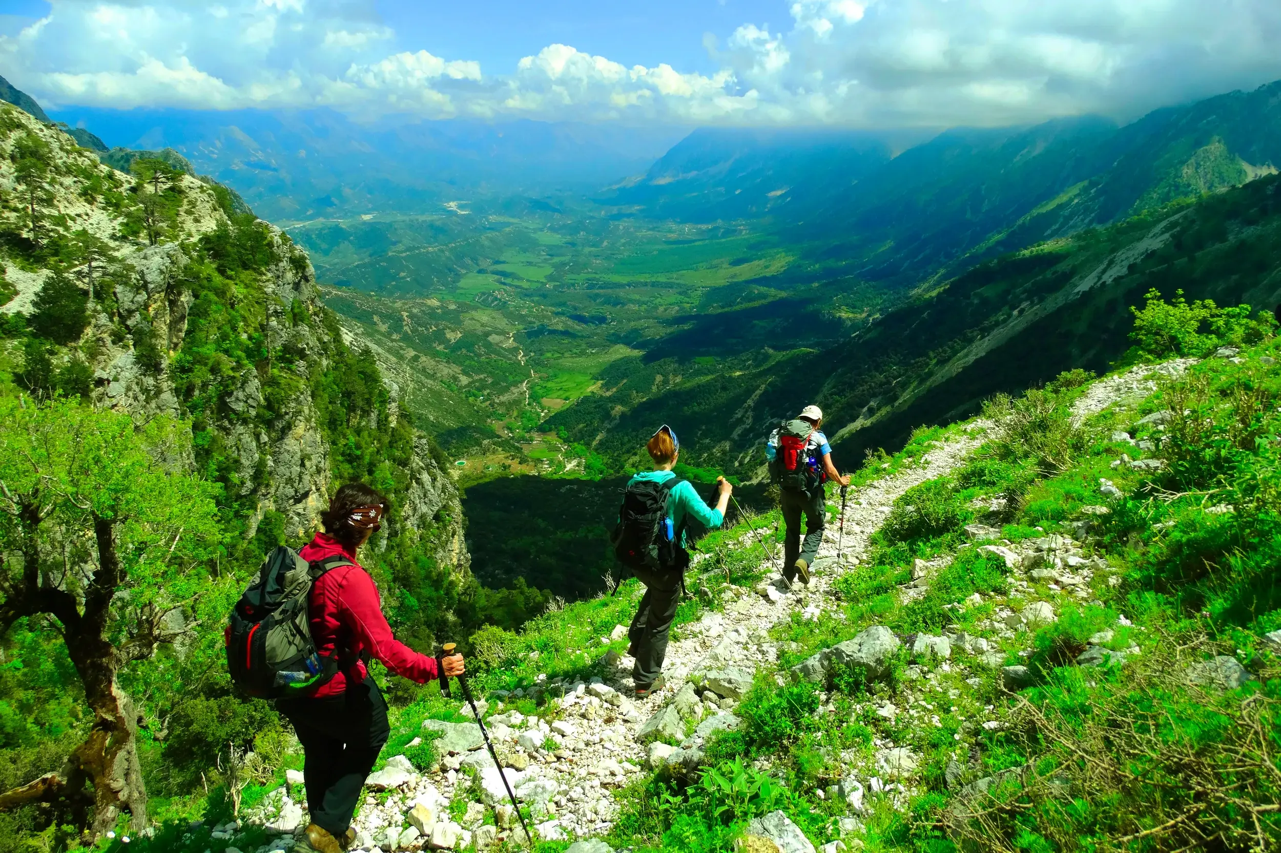 Eine Hauser-Wandergruppe auf einem felsigen Pfad mit Panoramablick über das Shushica-Tal im albanischen Küstengebirge.
