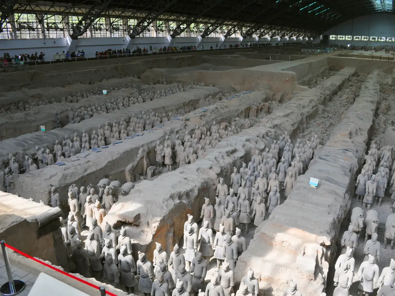 Hunderte lebensgroße Tonsoldaten der Terrakotta-Armee stehen in Reih und Glied in den Ausgrabungsgräben bei Xian, China.