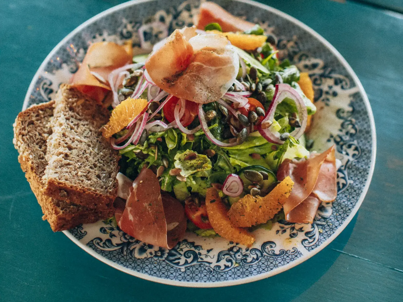 Bunter Salat mit norwegischem Schinken, Zwiebeln und Brot als Stärkung während einer Hauser Wanderreise auf den Lofoten.