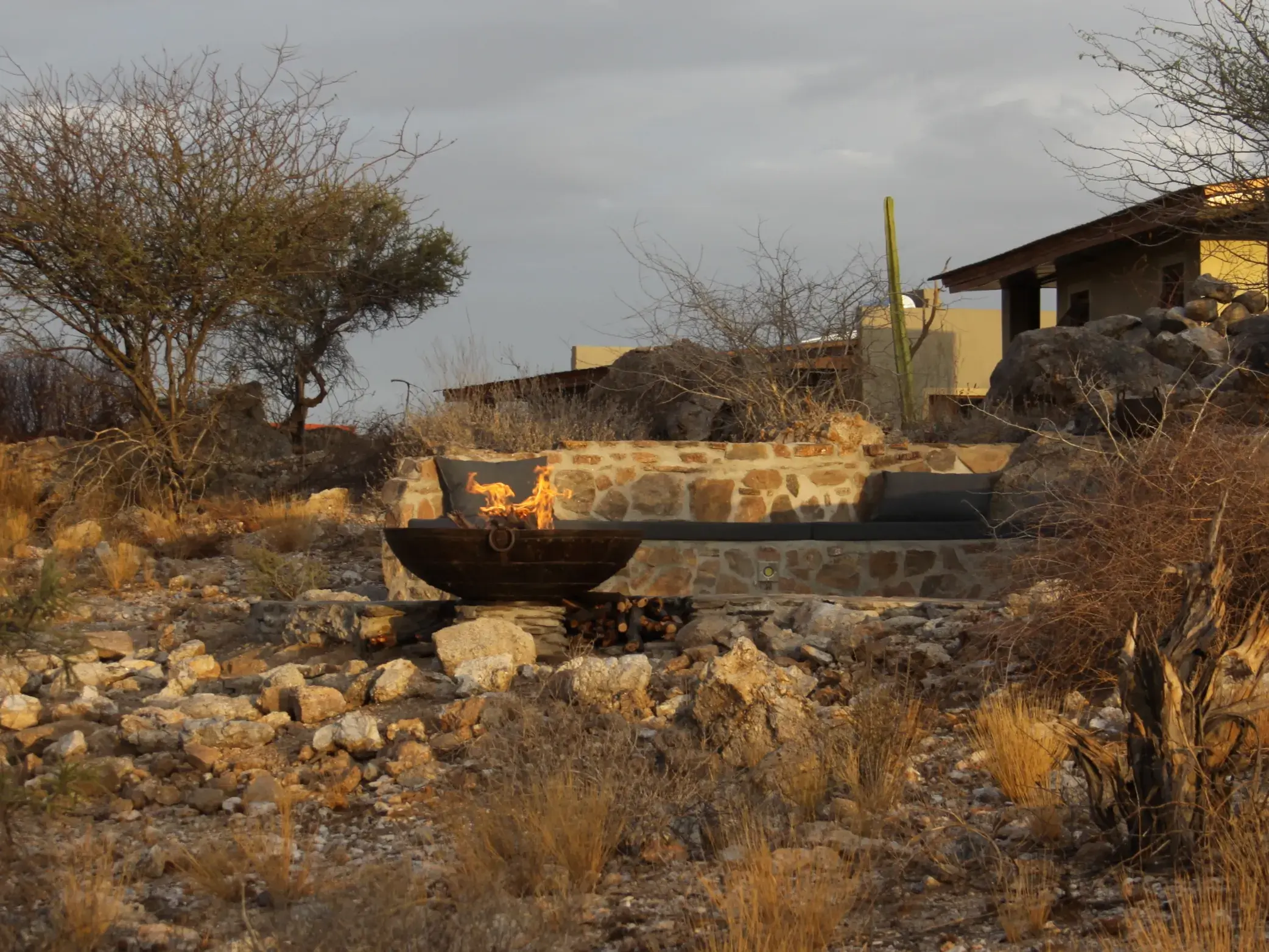 Gemütliche Feuerstelle einer Lodge in der Felsenlandschaft des Erongo-Gebirges in Namibia zum Sundowner.