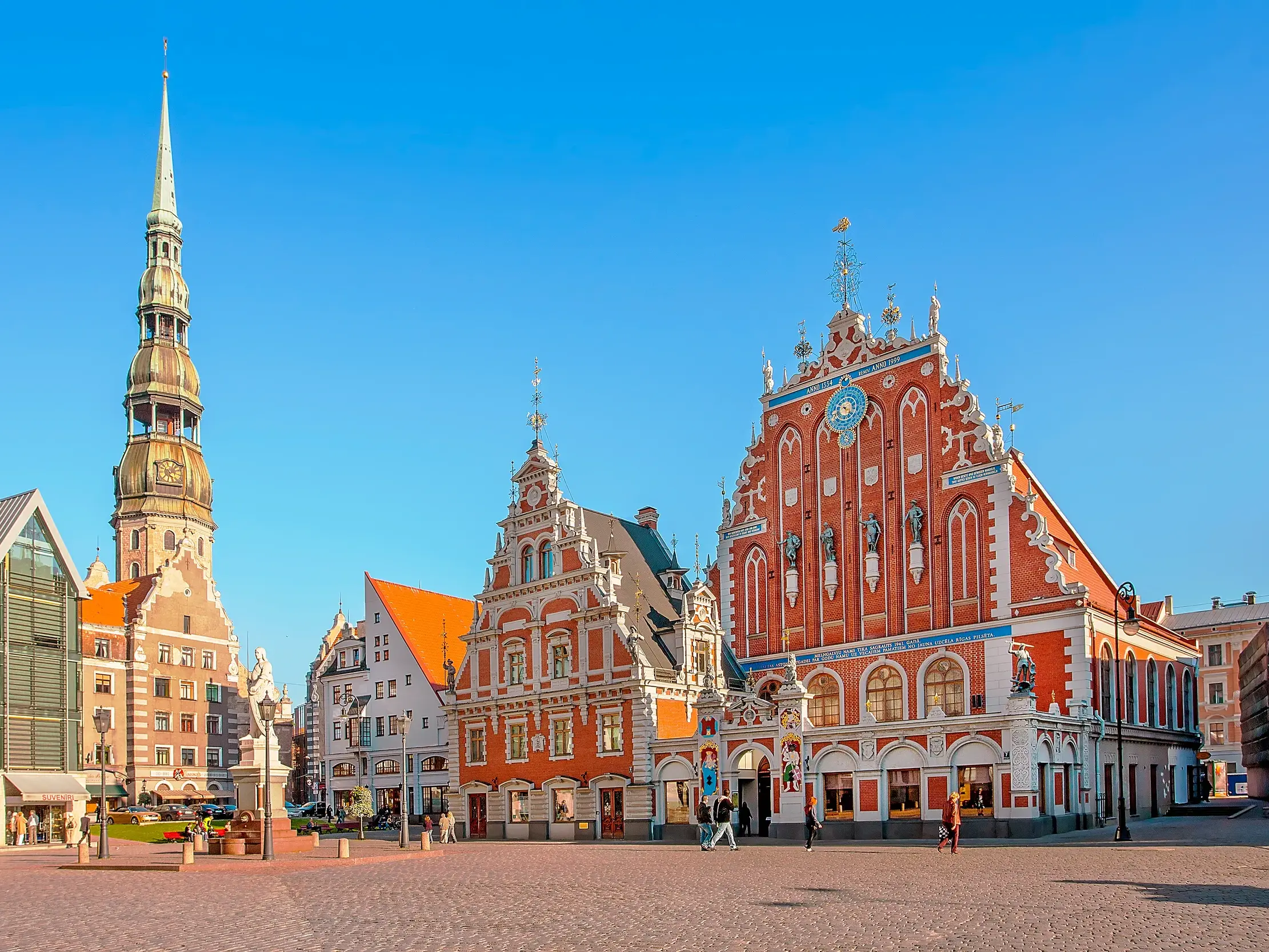 Sonnige Ansicht des Rathausplatzes in Riga mit dem historischen Schwarzhäupterhaus und dem Turm der Petrikirche.