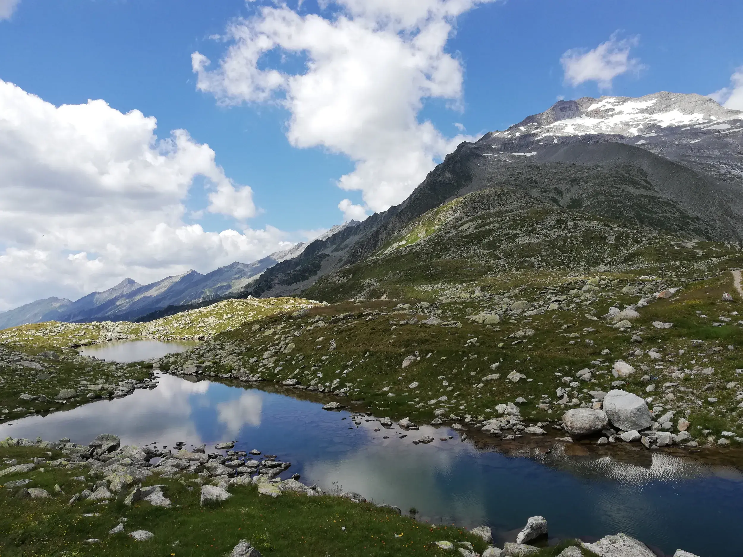 Ruhiger Bergsee in den Zillertaler Alpen auf der Alpenüberquerung zum Pfitscher Joch in Südtirol.