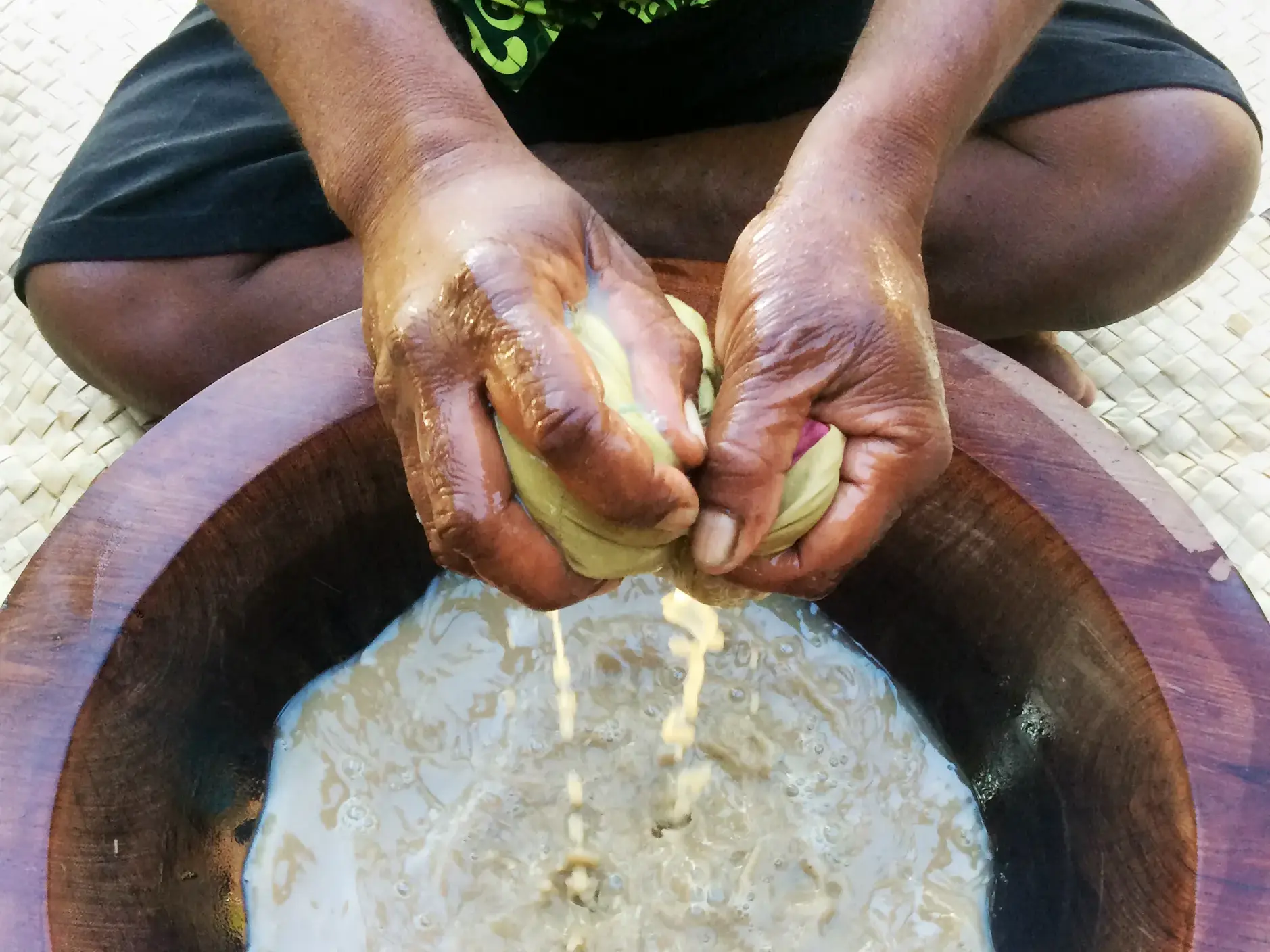 Nahaufnahme von Händen, die für eine Willkommenszeremonie auf Fiji Kava, den traditionellen Zeremonialtrunk, zubereiten.