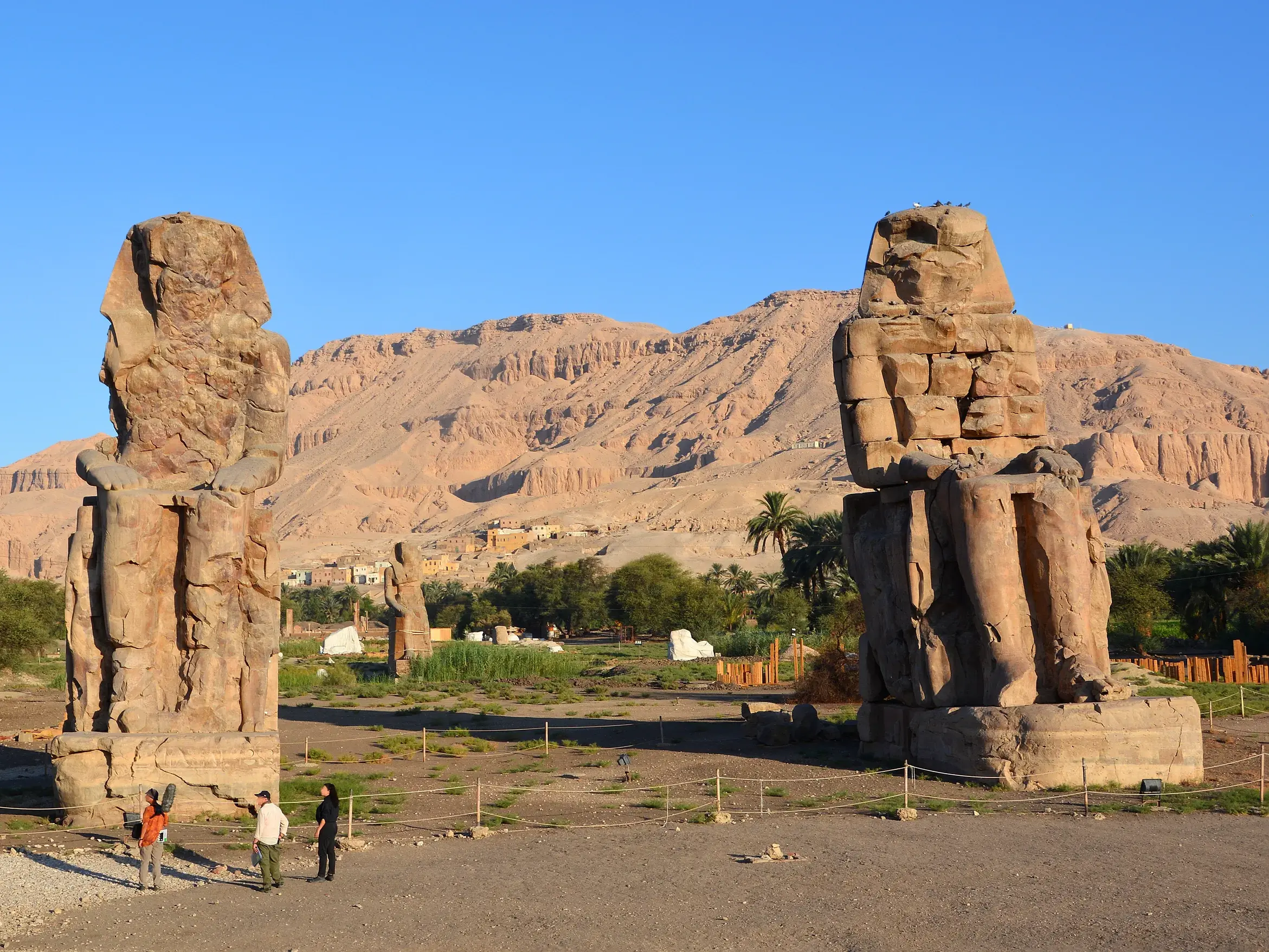 Eine Reisegruppe bestaunt auf ihrer Studienreise die gewaltigen Memnonkolosse in Theben-West bei Luxor.