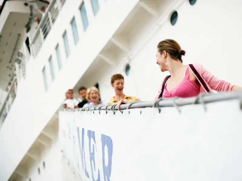 Reisende einer Kleingruppe lachen gut gelaunt an Deck eines Schiffes während der Yangzi-Flusskreuzfahrt in China.