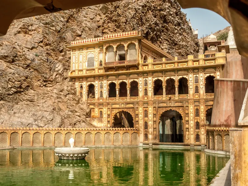 Der malerische Galtaji Tempel bei Jaipur, eingebettet in ein Felsental der Aravalli-Berge, spiegelt sich im Wasser.