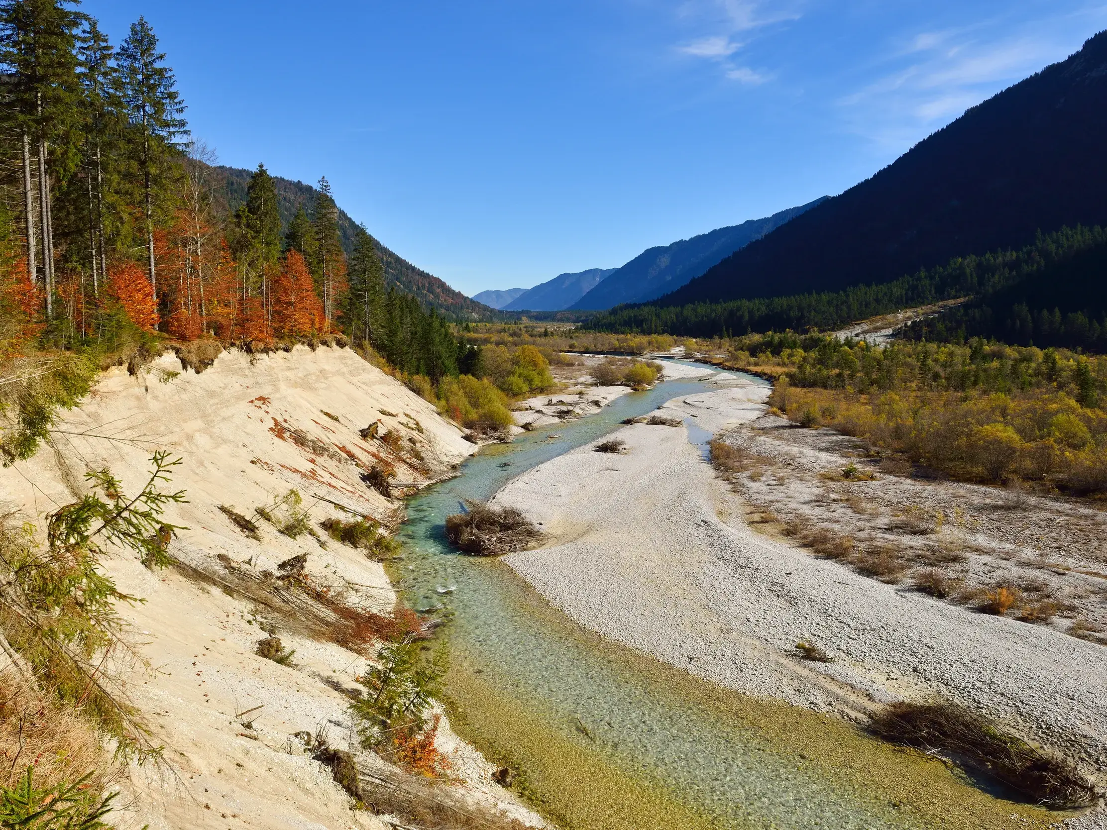Wildflusslandschaft der Isar in Bayrisch-Kanada mit türkisfarbenem Wasser, Kiesbänken und herbstlichen Wäldern im Karwendel.