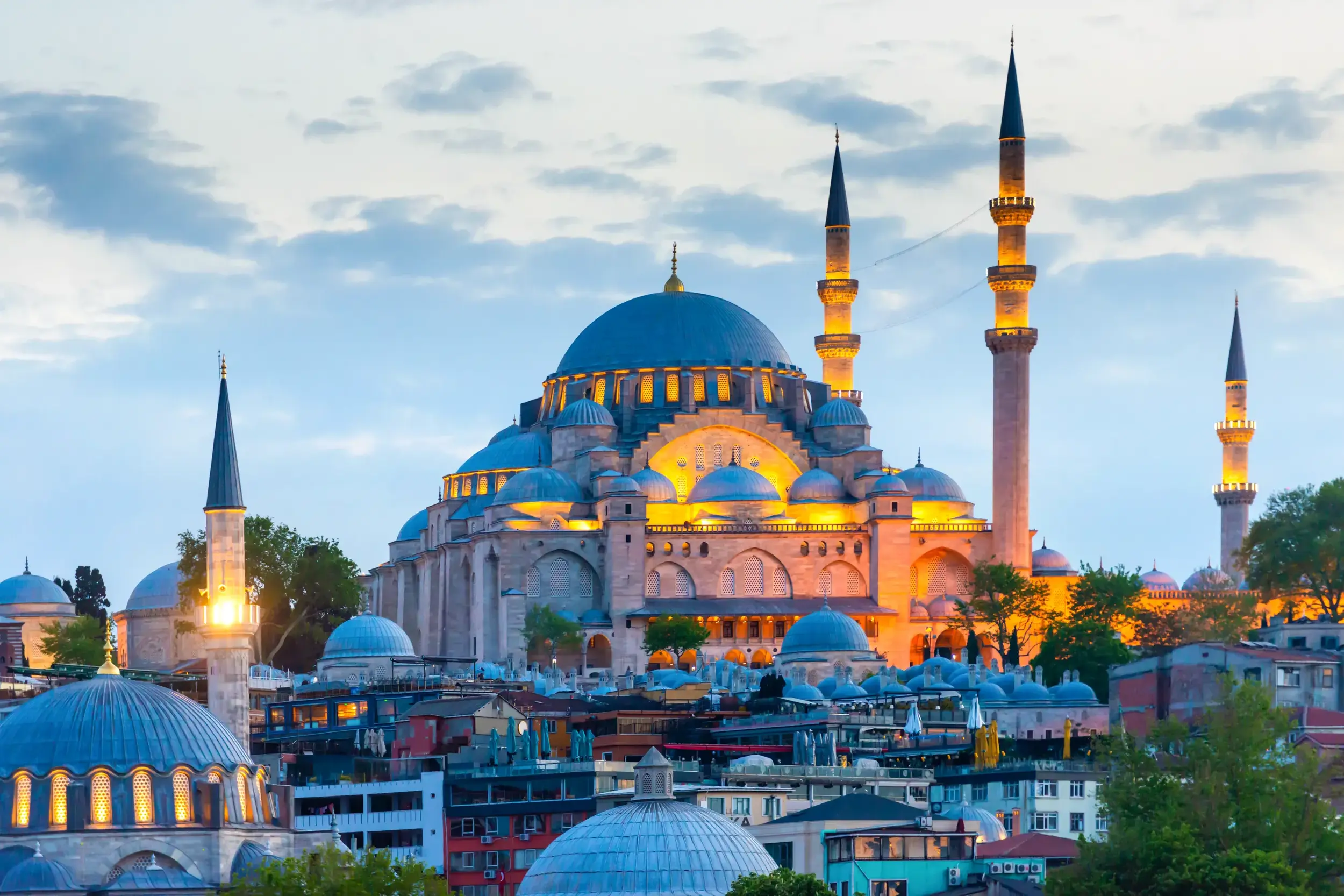 Die prachtvolle Süleyman-Moschee in Istanbul, deren Kuppeln und Minarette in der Abenddämmerung hell erleuchtet sind.