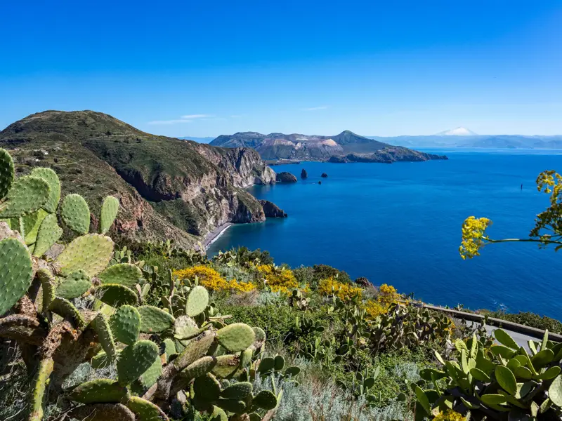 Aussicht bei einer Wanderung auf den Äolischen Inseln über die Steilküste und das Meer zur Insel Vulcano und dem Ätna.