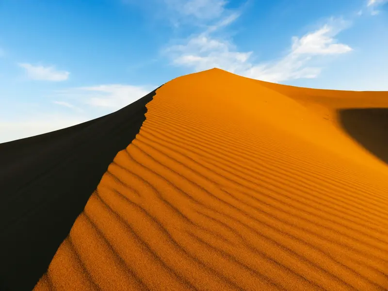 Majestätischer Dünenkamm in Marokkos Sahara mit feiner Sandstruktur, ein Highlight beim Wüstentrekking im Erg Chegaga.