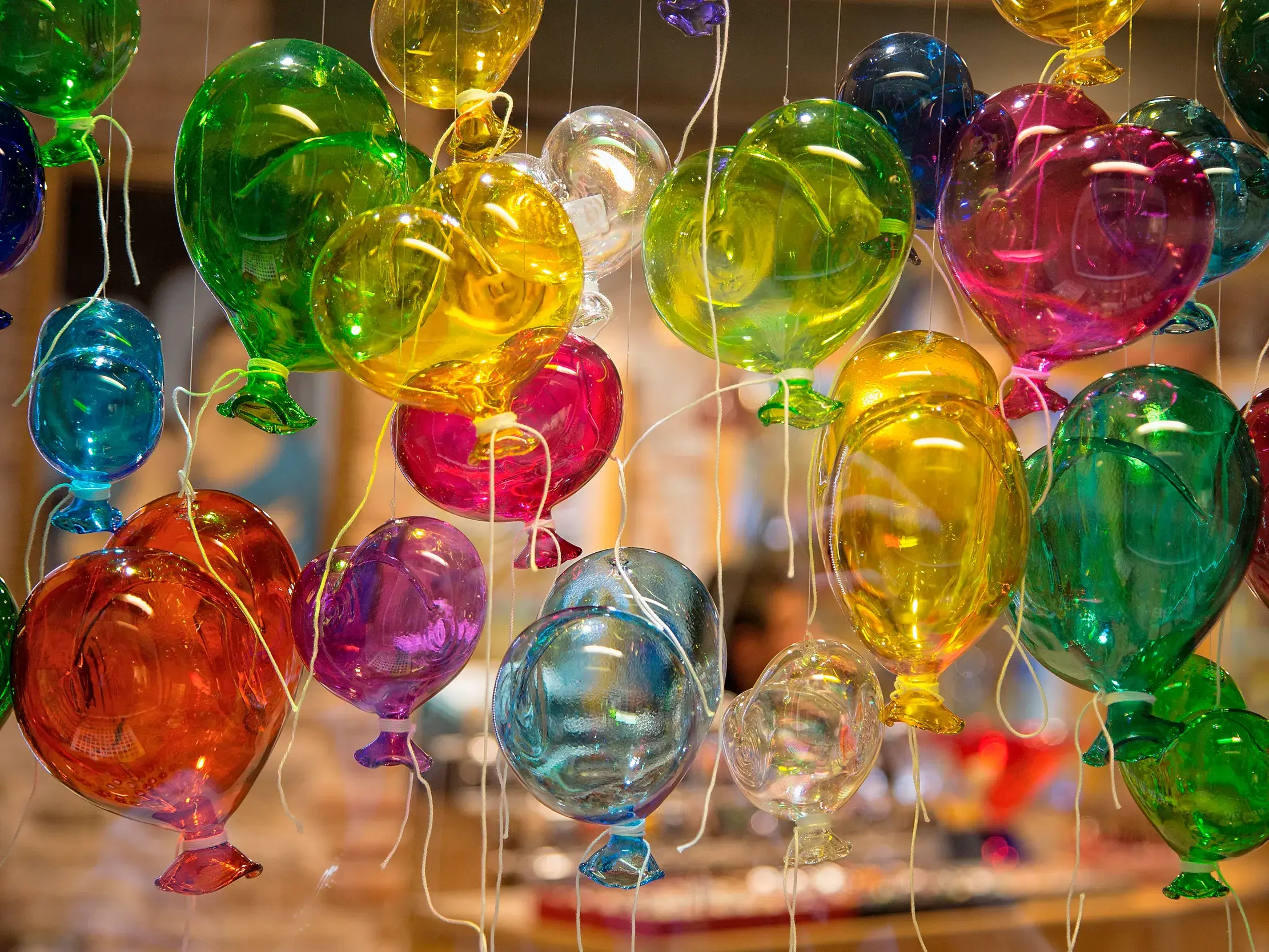 Filigrane, bunte Luftballons aus Muranoglas schweben als Dekoration in einem Geschäft auf der Insel Murano bei Venedig.