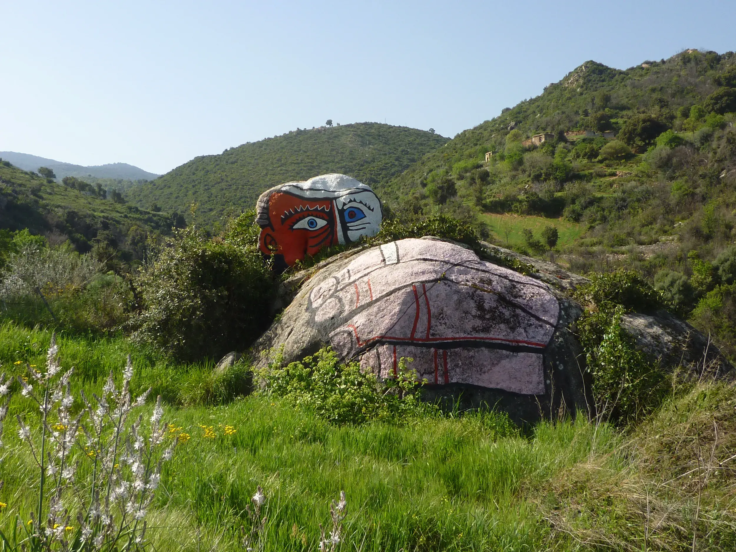 Künstlerisch bemalte Granitfelsen inmitten der grünen Macchia Sardiniens auf einer Wanderung in der Region um Onifai.