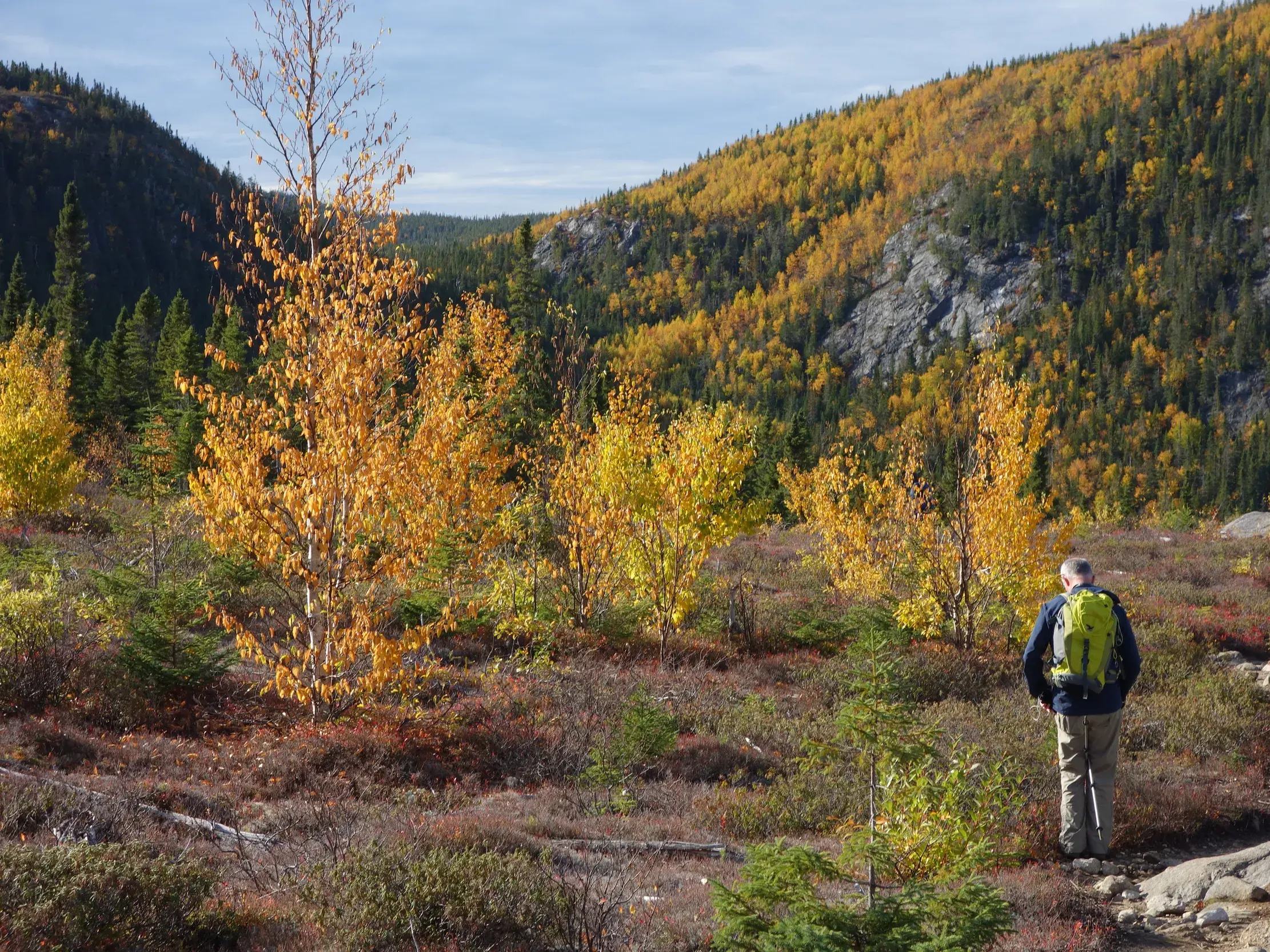 Zwei Wanderer auf einem Pfad durch die farbenprächtige Herbstlandschaft eines Nationalparks in Québec im Indian Summer.