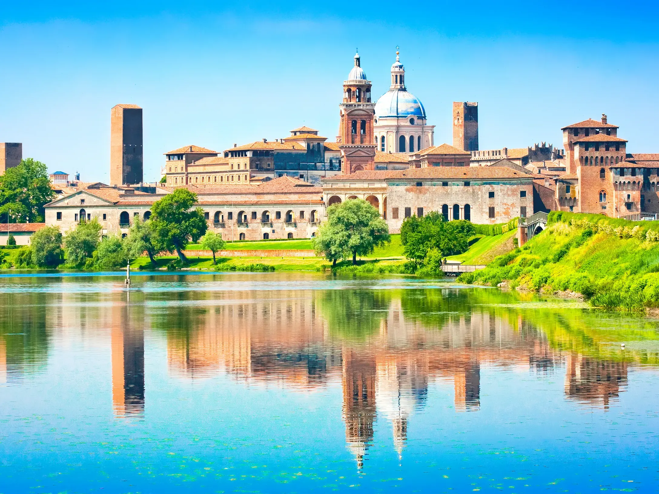 Die historische Skyline von Mantua in der Lombardei, mit dem Palazzo Ducale, spiegelt sich malerisch im Wasser.