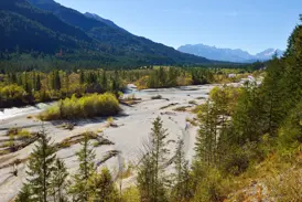 Blick beim Trekking auf die unberührte Wildflusslandschaft der Isar in Bayrisch-Kanada mit dem Karwendel im Hintergrund.