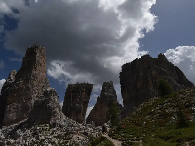 Wanderer auf dem Höhenweg Alta Via 1 mit Blick auf die beeindruckenden Felsnadeln der Cinque Torri in den Dolomiten.