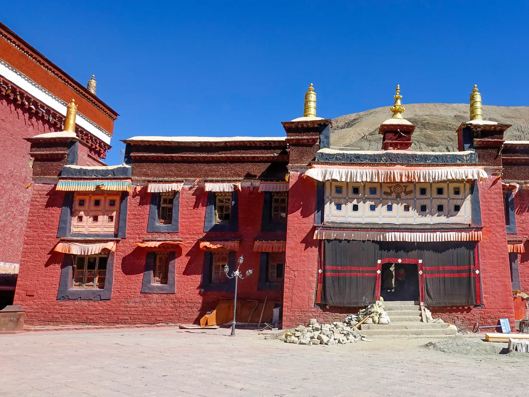 Die traditionelle, rote Fassade des monumentalen Sakya-Klosters in Tibet unter klarem, blauem Himmel auf einer Studienreise.