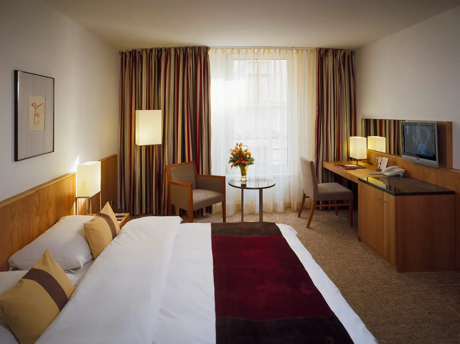 Modern eingerichtetes Doppelzimmer im zentral gelegenen Hotel Ihrer Städtereise in Budapest mit bequemem Bett und Schreibtisch.