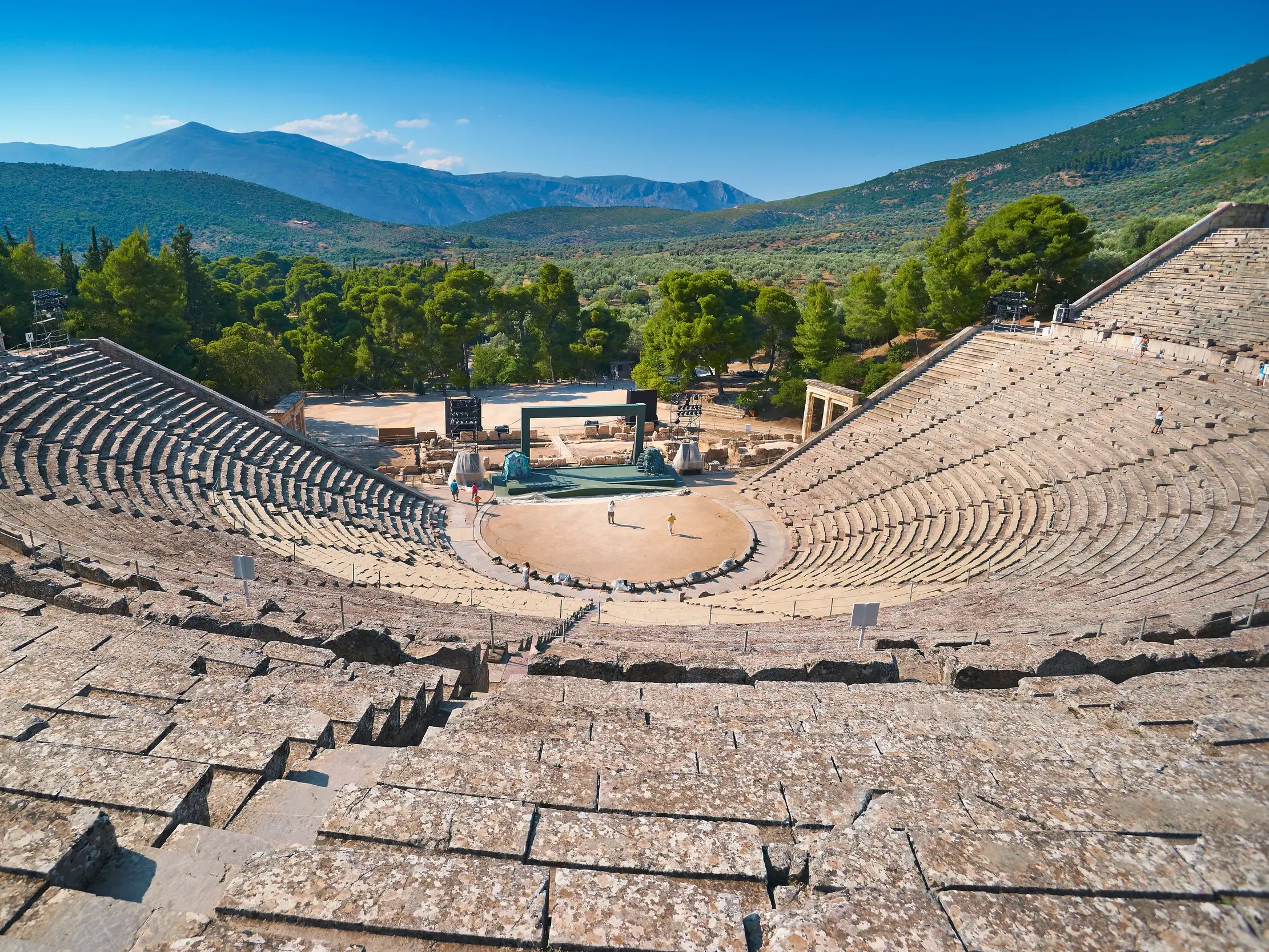 Majestätischer Blick auf das gut erhaltene Theater von Epidauros, eingebettet in die grüne Berglandschaft des Peloponnes.