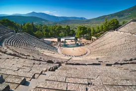 Majestätischer Blick auf das gut erhaltene Theater von Epidauros, eingebettet in die grüne Berglandschaft des Peloponnes.