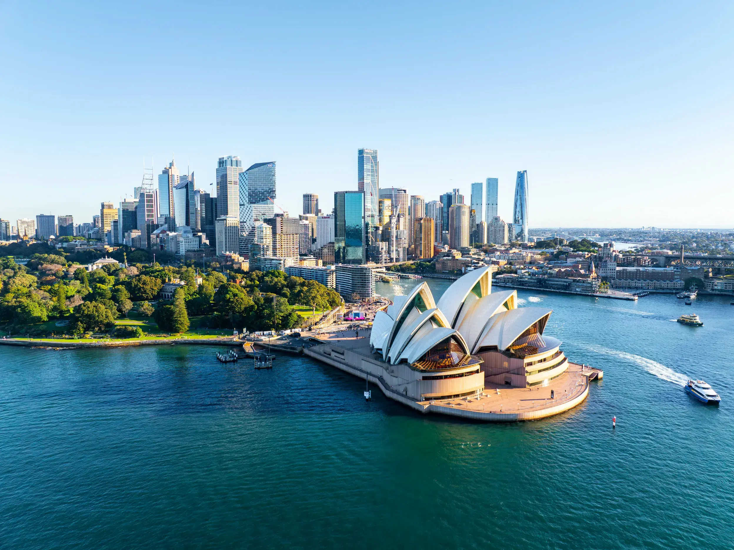 Das ikonische Sydney Opera House und die Skyline der Stadt vom Hafen aus gesehen auf einer Studienreise in Australien.