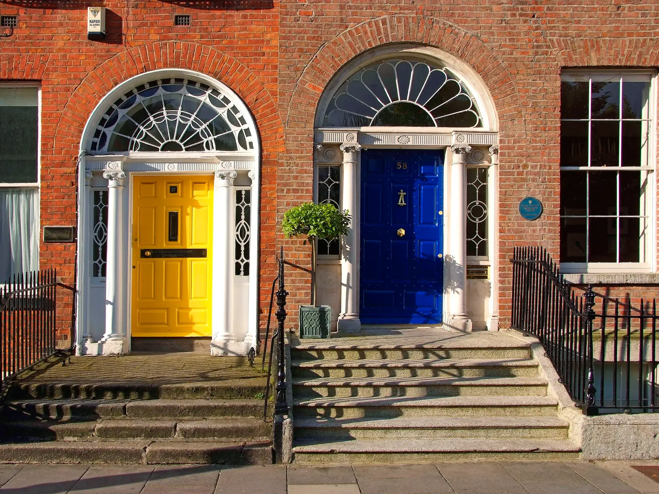 Die berühmten bunten „Doors of Dublin“: Eine gelbe und eine blaue Tür an einer typischen georgianischen Backsteinfassade.