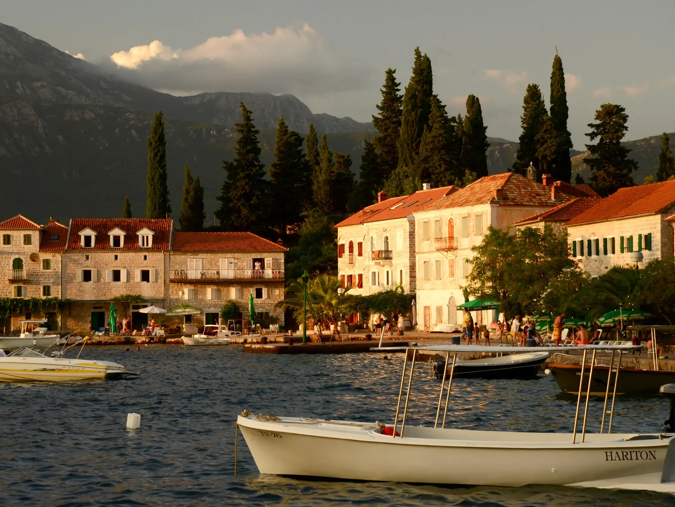 Malerische Steinhäuser des Küstenortes Perast in der Bucht von Kotor, im Hintergrund ragen die Berge Montenegros auf.