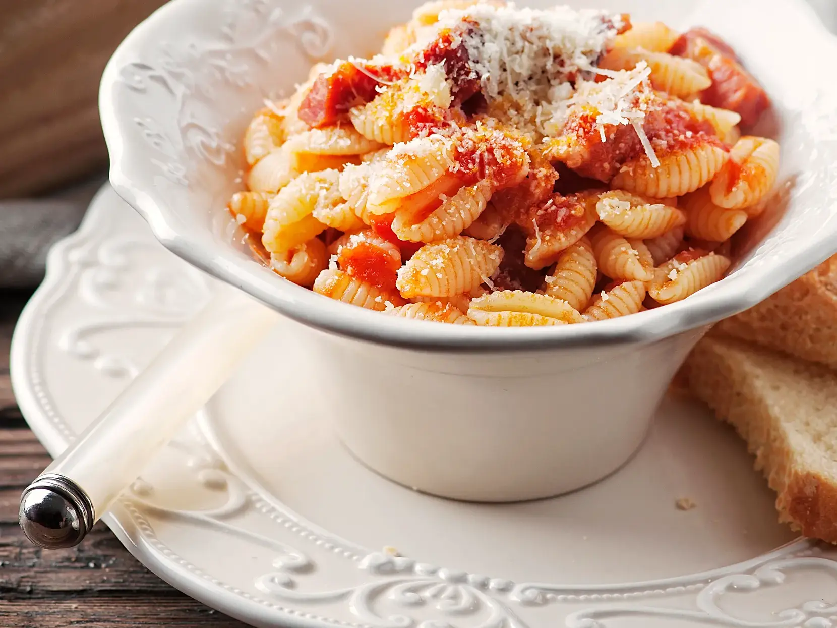 Traditionelle Gnocchetti Sardi mit Tomatensoße und Käse in einer weißen Schale, eine kulinarische Entdeckung auf Sardinien.