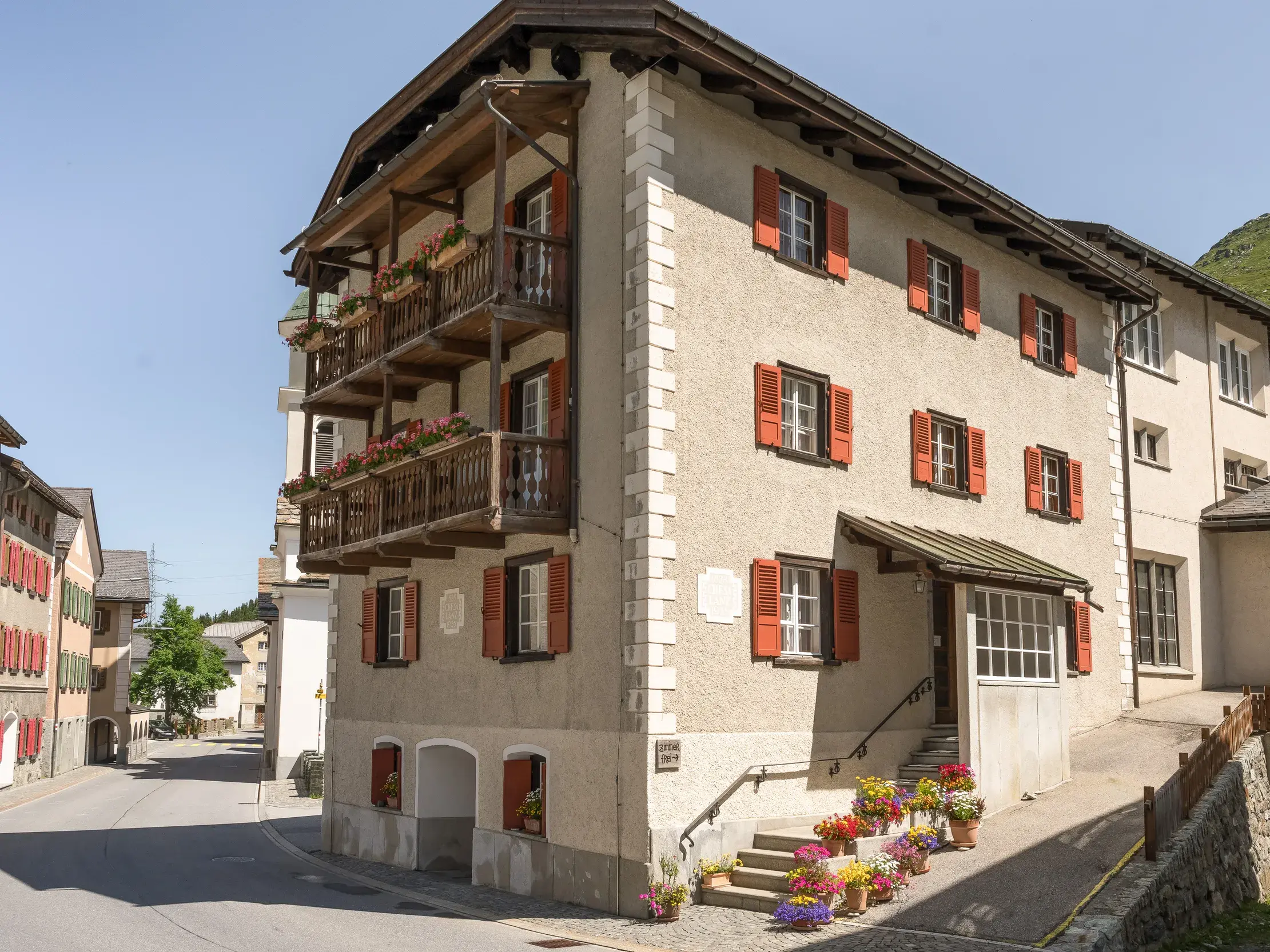 Das traditionelle Hotel im Bergdorf Bivio mit roten Fensterläden, Ausgangspunkt für Wanderungen in den Graubündner Alpen.