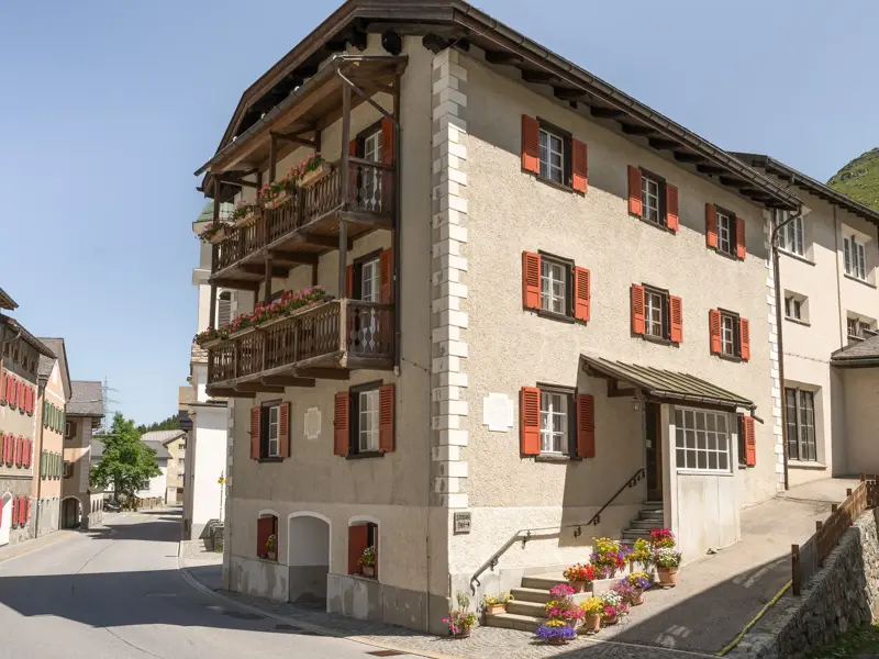 Das traditionelle Hotel im Bergdorf Bivio mit roten Fensterläden, Ausgangspunkt für Wanderungen in den Graubündner Alpen.