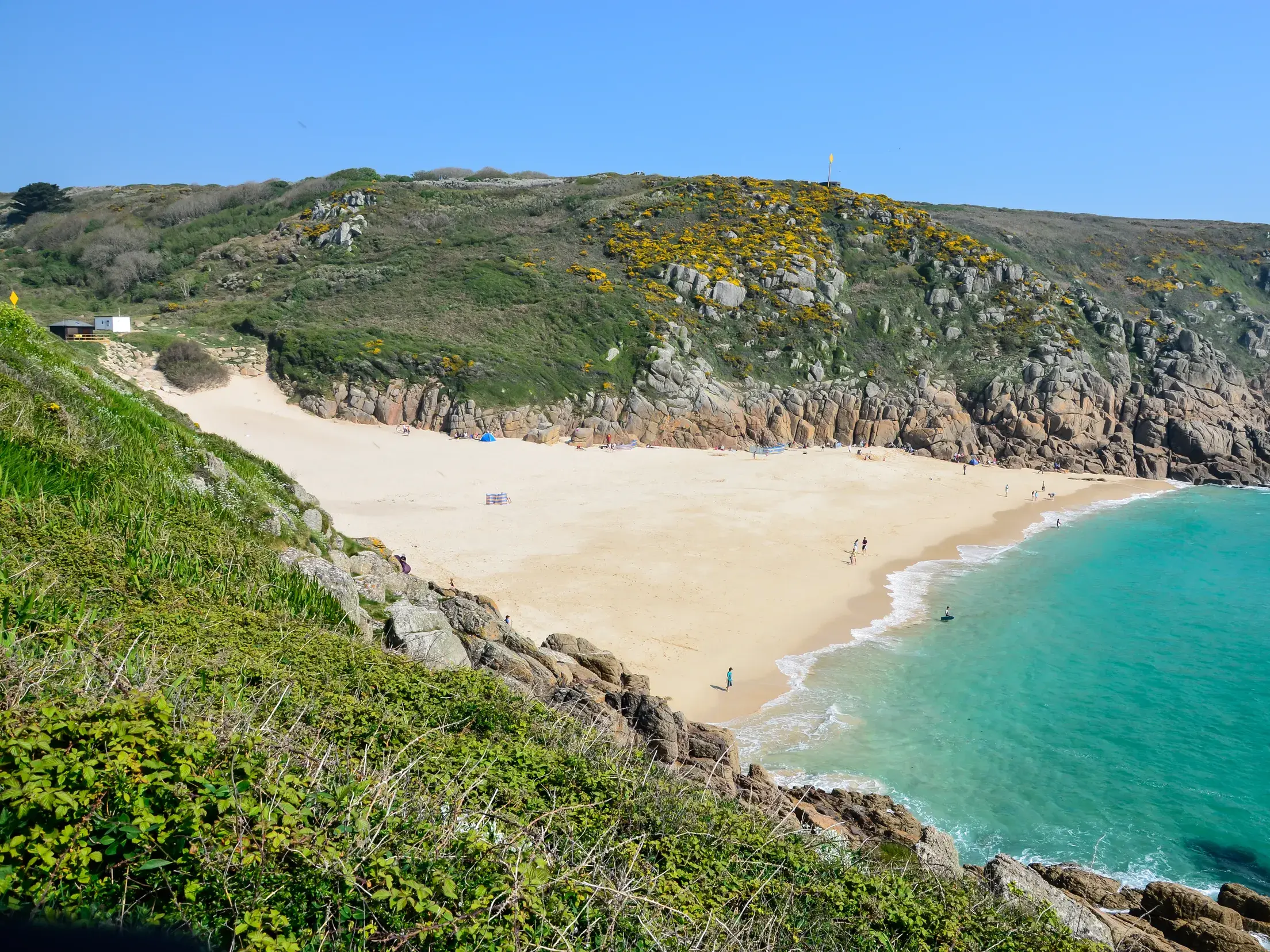 Beim Trekking auf dem South West Coast Path eröffnet sich der Blick auf die malerische Bucht von Porthcurno in Cornwall.