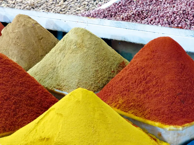 Farbenprächtige, zu Pyramiden aufgetürmte orientalische Gewürze auf einem traditionellen Souk in Marrakesch.