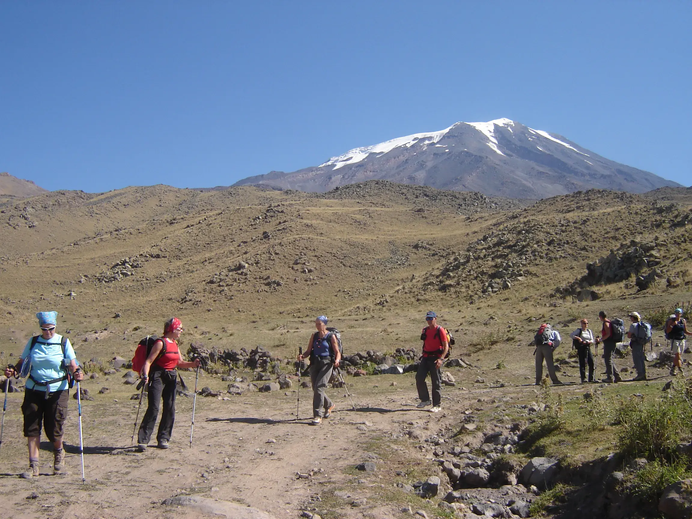 Eine Hauser-Wandergruppe beim Trekking durch die karge Berglandschaft der Osttürkei mit dem schneebedeckten Ararat im Blick.