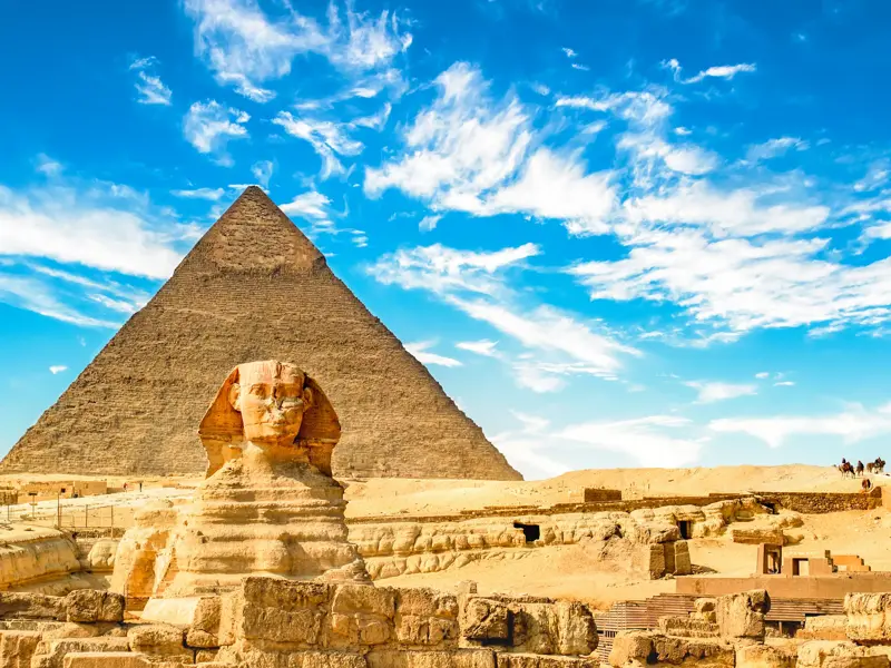 Der steinerne Sphinx wacht als Pyramidenwächter vor den Pyramiden von Gizeh bei Kairo unter einem blauen Sommerhimmel.