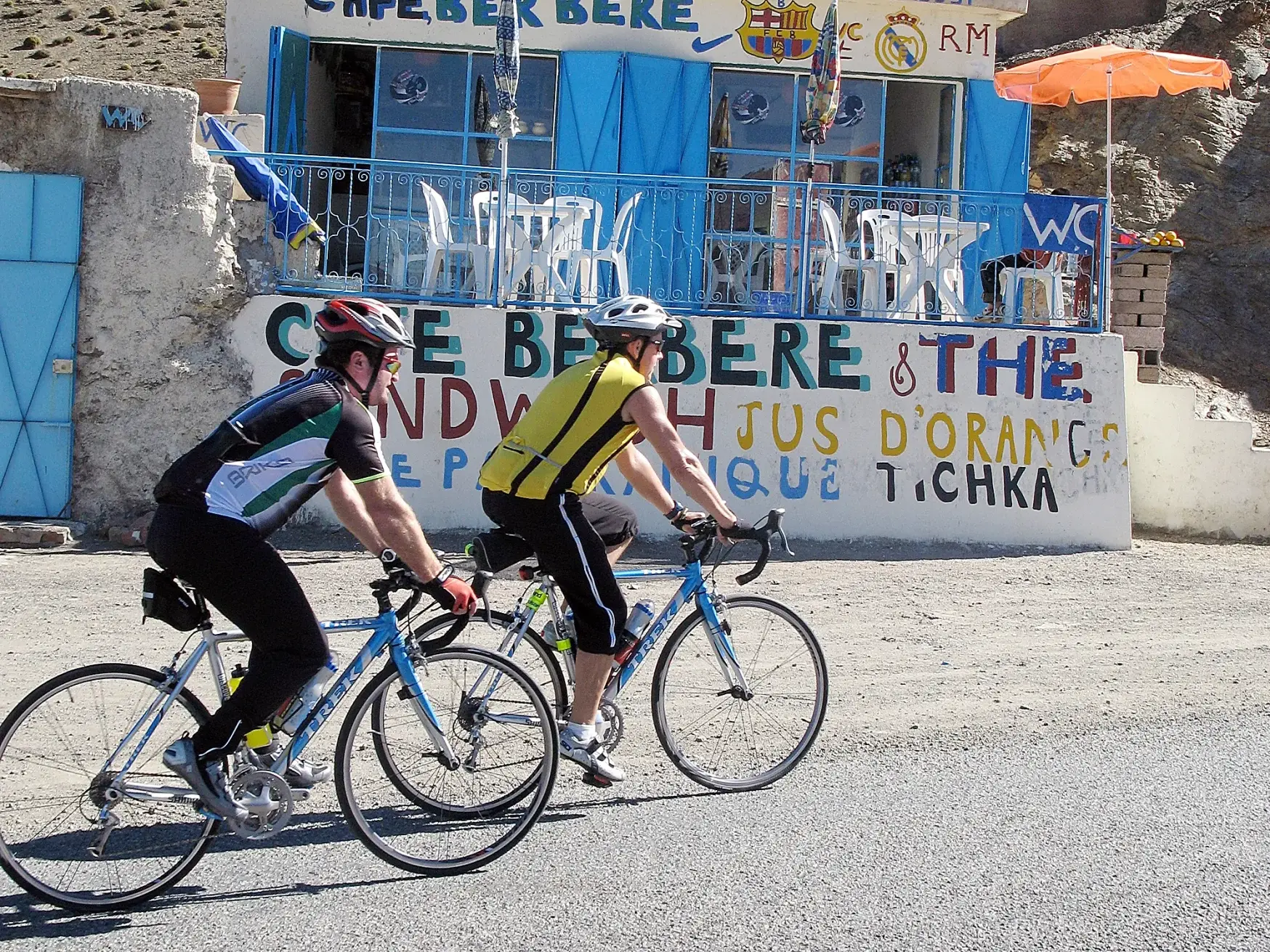 Zwei Radfahrer einer Gruppenreise auf Rennrädern erklimmen die Passstraße des Tizi n'Tichka im marokkanischen Atlasgebirge.