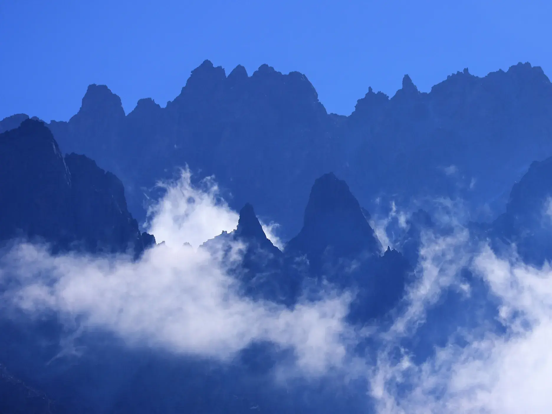 Panorama der schroffen Gipfel des Terskej-Alatau-Gebirges, umgeben von Wolken, bei einer Trekking-Reise in Kirgistan.