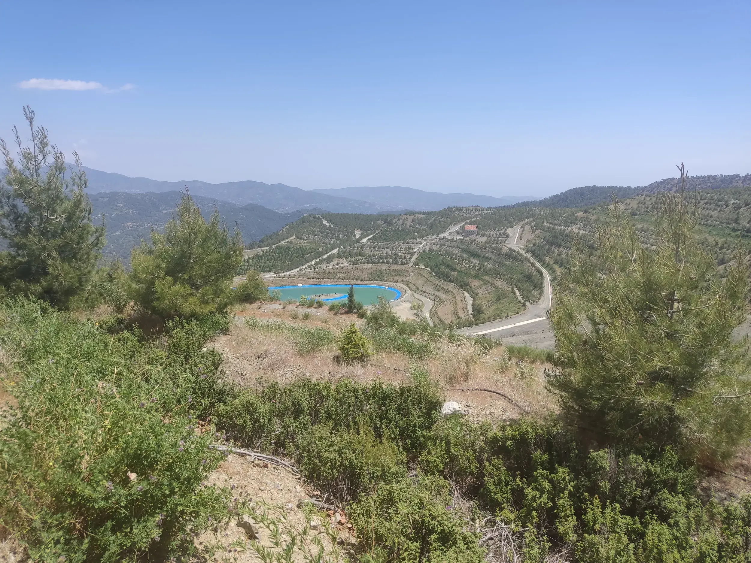 Ausblick von einem Wanderweg auf terrassierte Hänge und einen Stausee im Marathasa-Tal im Troodos-Gebirge auf Zypern.