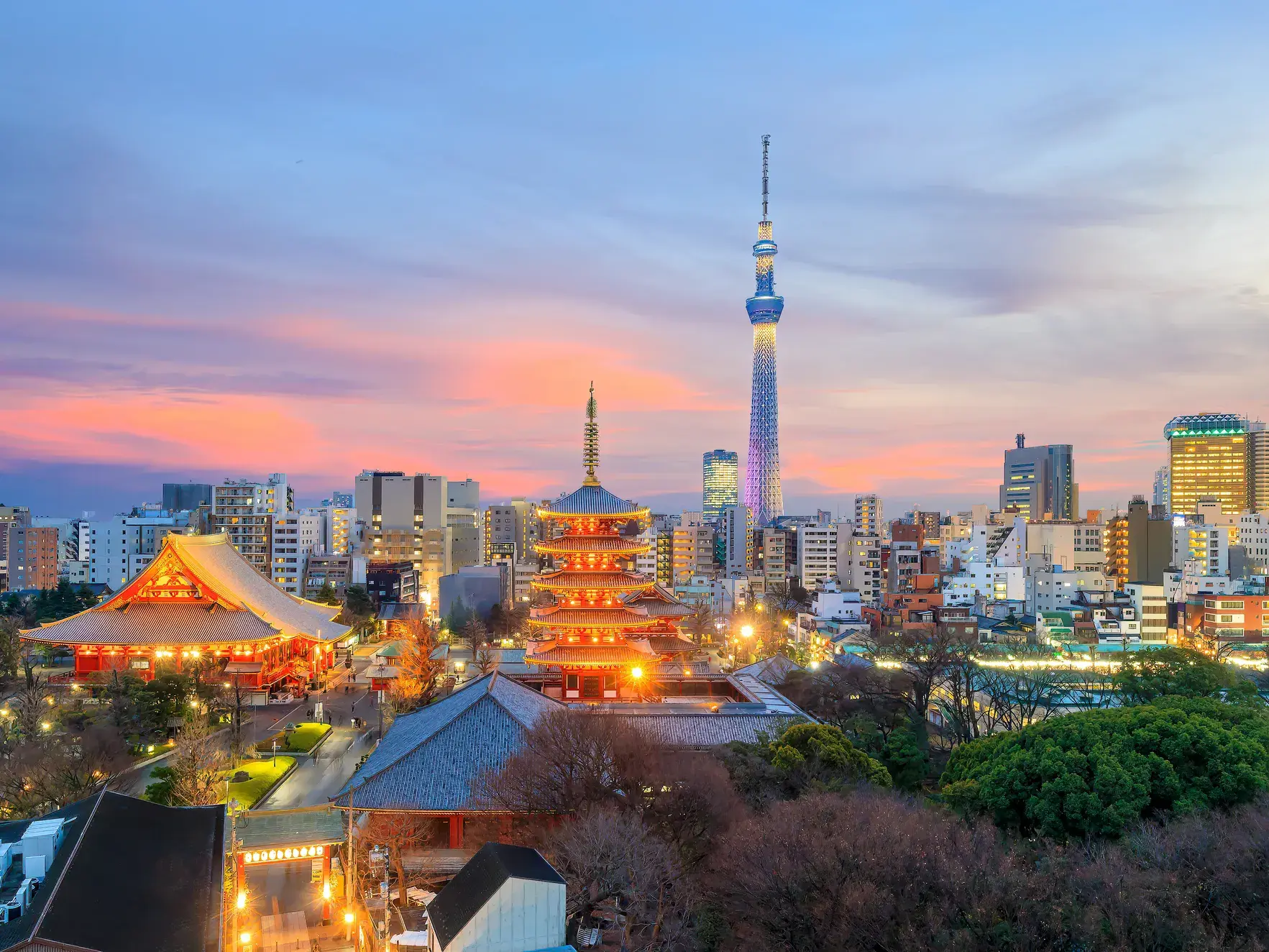 Der beleuchtete Sensō-ji Tempel und die Pagode vor der modernen Skyline Tokios mit dem Tokyo Skytree bei Sonnenuntergang.
