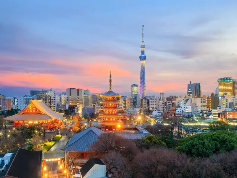 Der beleuchtete Sensō-ji Tempel und die Pagode vor der modernen Skyline Tokios mit dem Tokyo Skytree bei Sonnenuntergang.