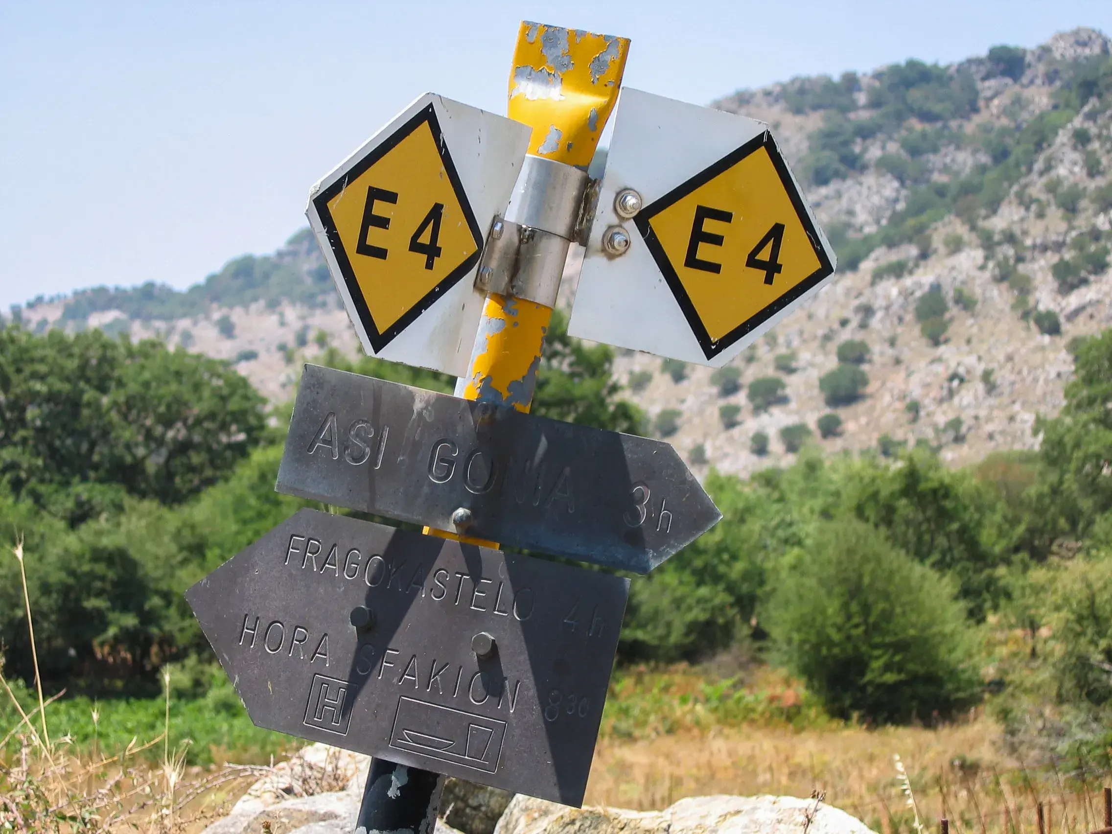 Wegweiser am Fernwanderweg E4 auf Kreta mit Zeitangaben für Wanderungen nach Chora Sfakion und Fragokastello.