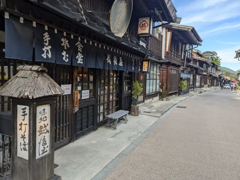 Ruhige Gasse mit traditionellen Holzhäusern in der historischen Poststadt Magome am Nakasendo-Wanderweg in Japan.