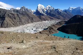 Trekking in Nepal: Wanderer blicken vom Renjo La Pass auf den türkisen Gokyo-See und den mächtigen Ngozumba-Gletscher.