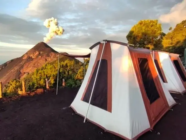 Zeltcamp auf dem Vulkan Acatenango in Guatemala mit atemberaubendem Blick auf den ausbrechenden Fuego Vulkan.