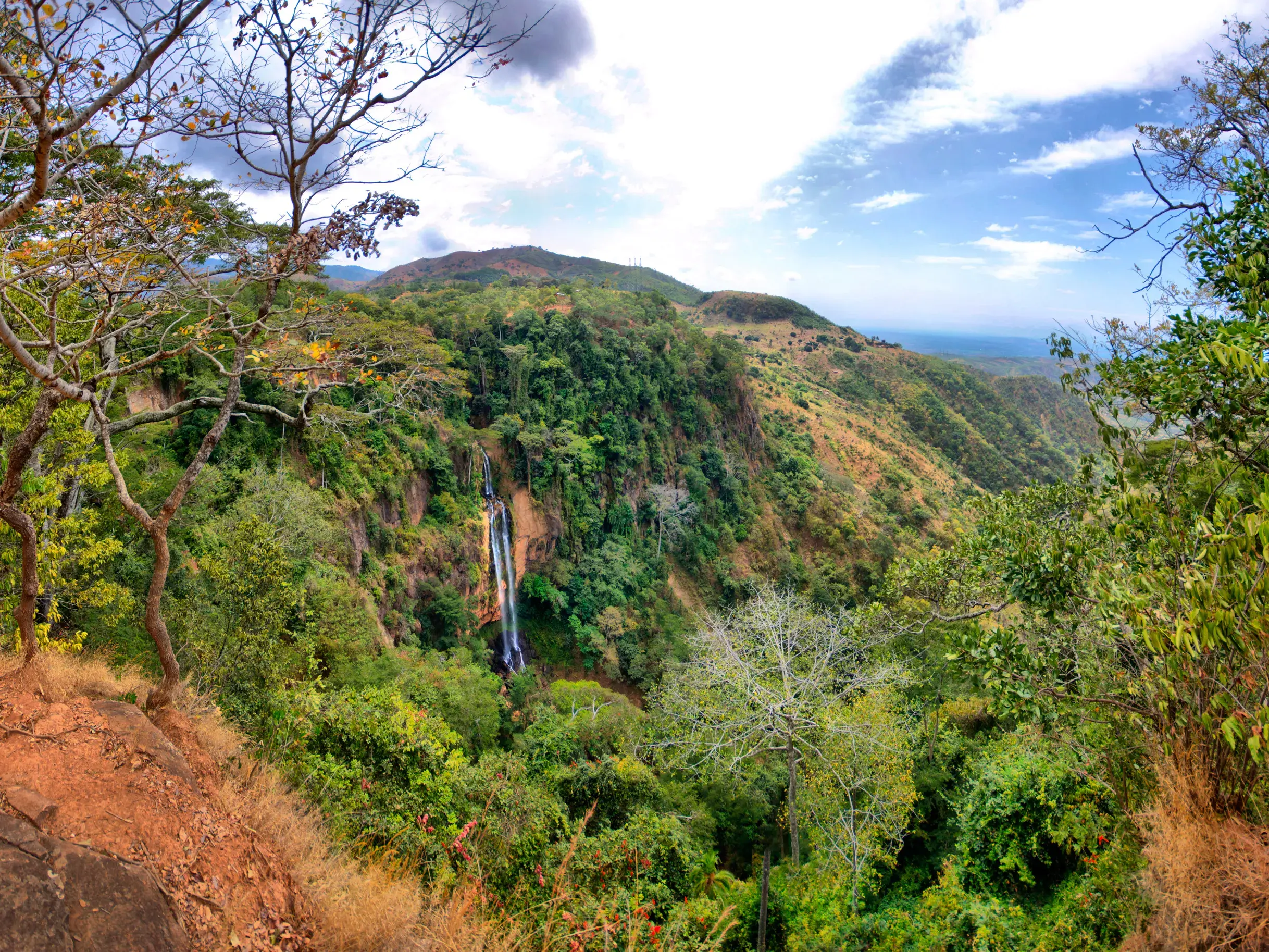 Weitblick von einem Trekking-Pfad auf die Dziwelankhalamba Wasserfälle im üppig grünen Mulanje Bergmassiv in Malawi.