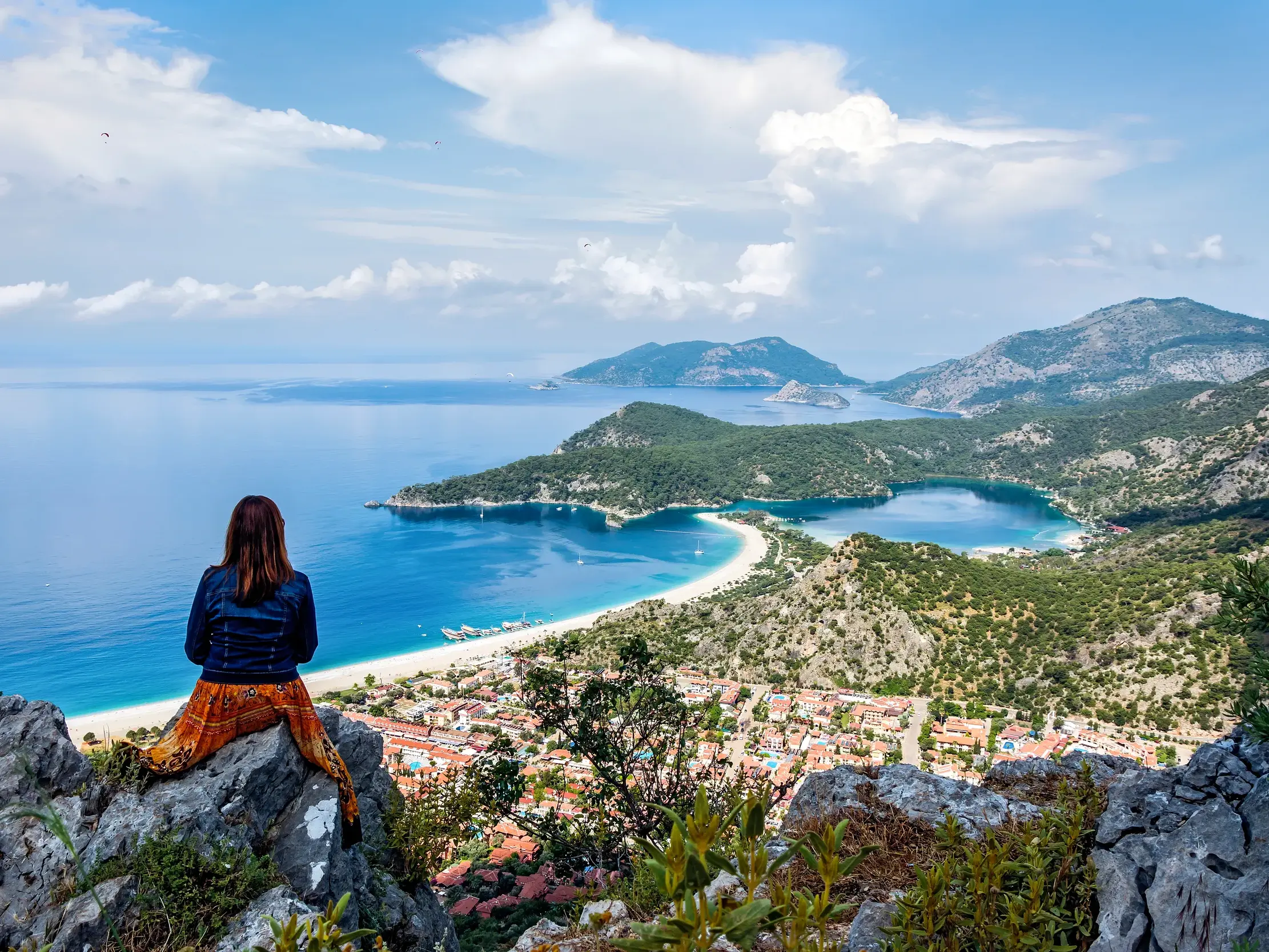 Reisende genießt den Panoramablick von einem Felsen auf das türkisblaue Meer und die Bucht an der Lykischen Küste.