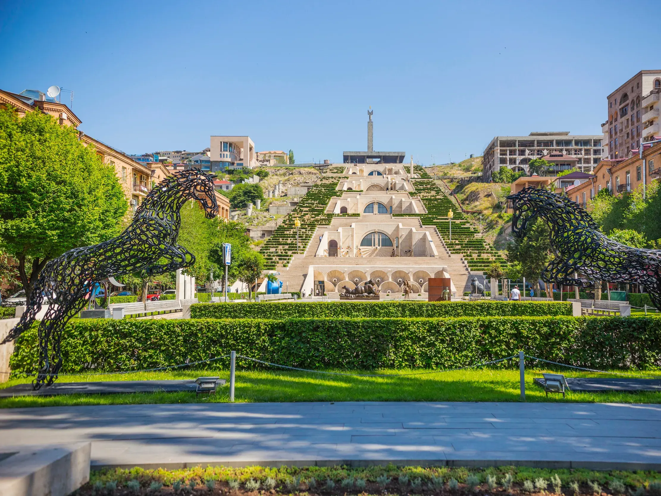 Moderne Pferdeskulpturen im Park vor der monumentalen Kaskaden-Treppe, eine berühmte Sehenswürdigkeit in Jerewan, Armenien.