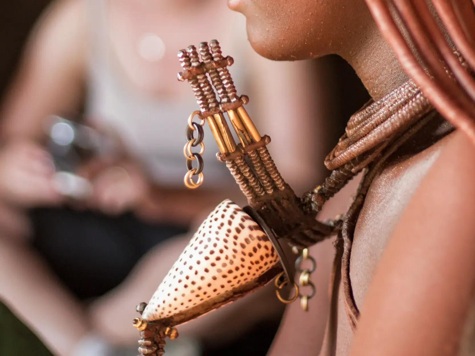 Kunstvoller traditioneller Schmuck mit einer gepunkteten Muschel am Hals einer einheimischen Frau in Namibia.