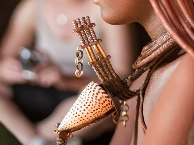 Kunstvoller traditioneller Schmuck mit einer gepunkteten Muschel am Hals einer einheimischen Frau in Namibia.