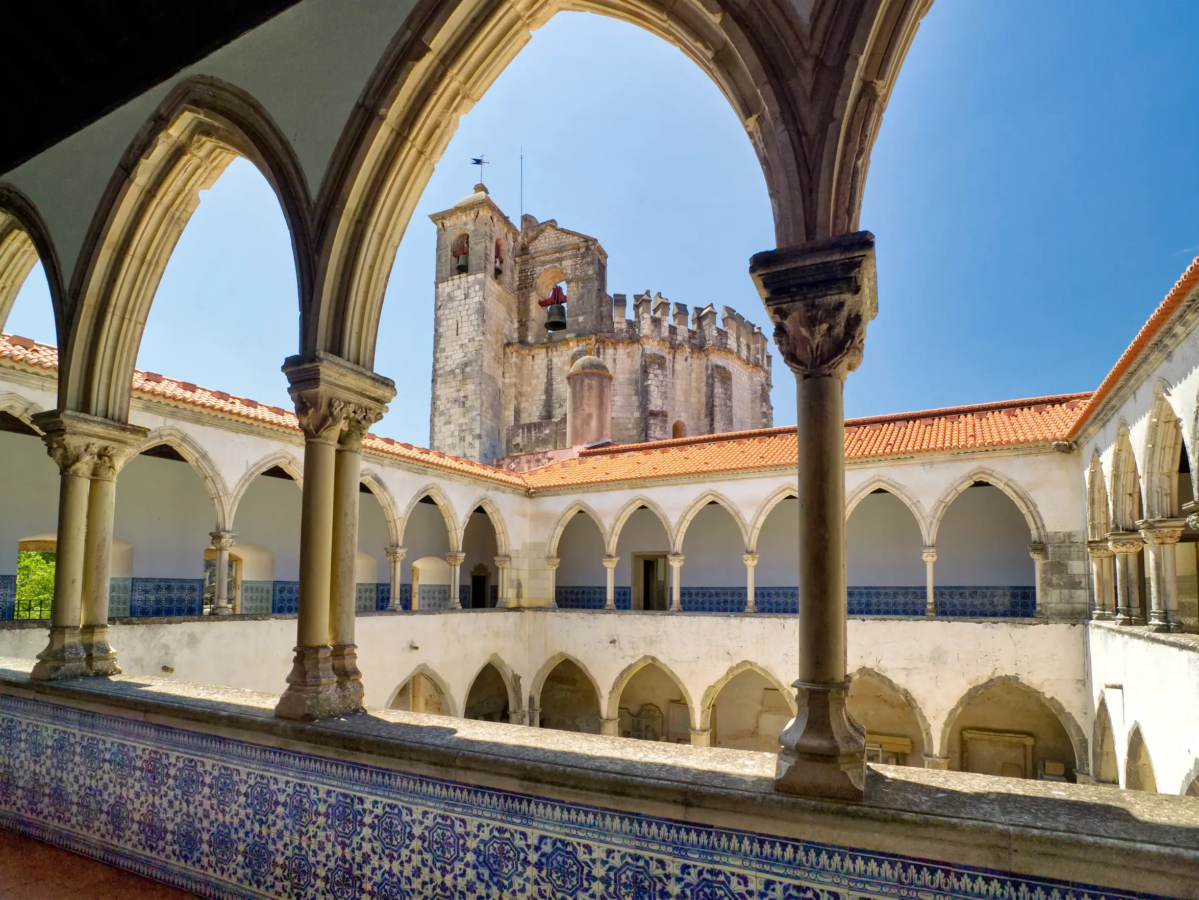 Sonniger Blick vom Kreuzgang auf den Innenhof der wehrhaften Festung Tomar, einem UNESCO-Welterbe in Portugal.