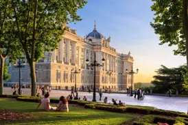 Besucher genießen die Abendsonne vor dem prachtvollen Königspalast von Madrid auf einer Studienreise durch Kastilien.